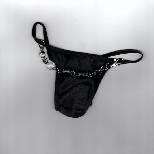 Accessoire de lingerie artisanal Ines Pineau, string noir accessoirisé d'une chaîne upcyclée avec perle et mousquetons, création parisienne.