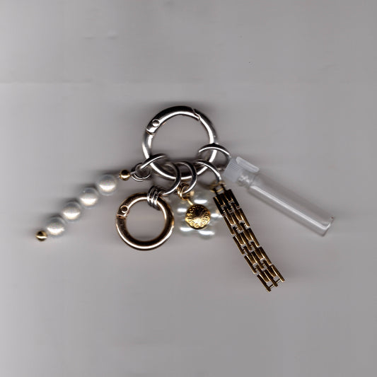 Bijou de sac Ines Pineau avec fiole à parfum vide, perles et maillons dorés upcyclés, fait main à Paris.